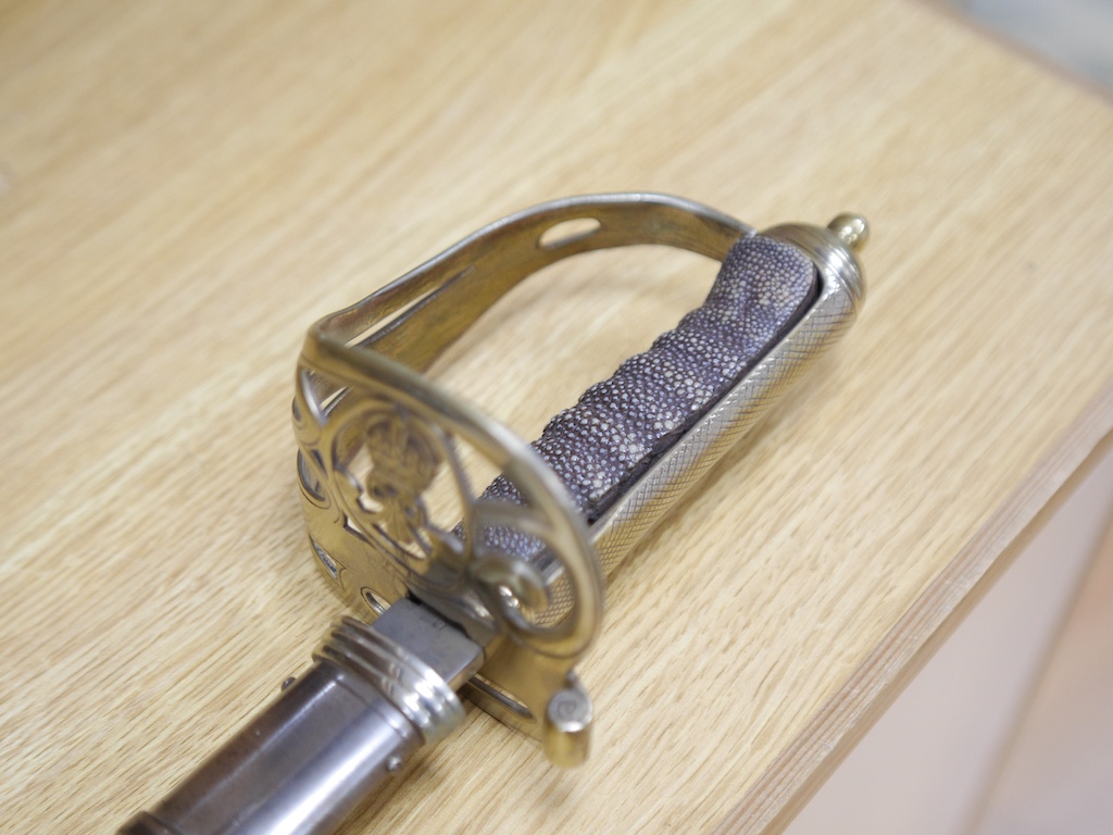 An officer's sword and WWII helmet. Condition - fair